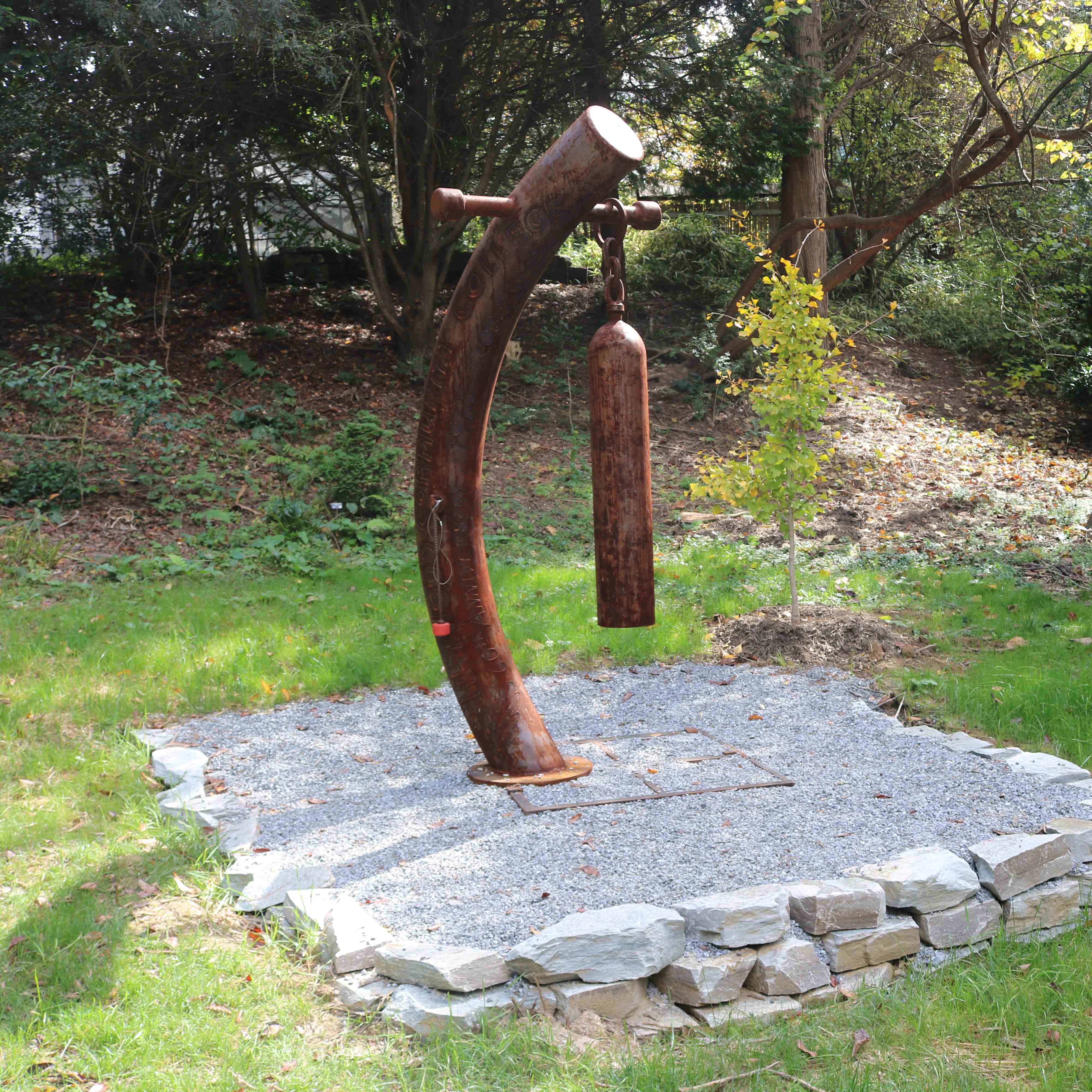 curved metal gong in a gravel pad